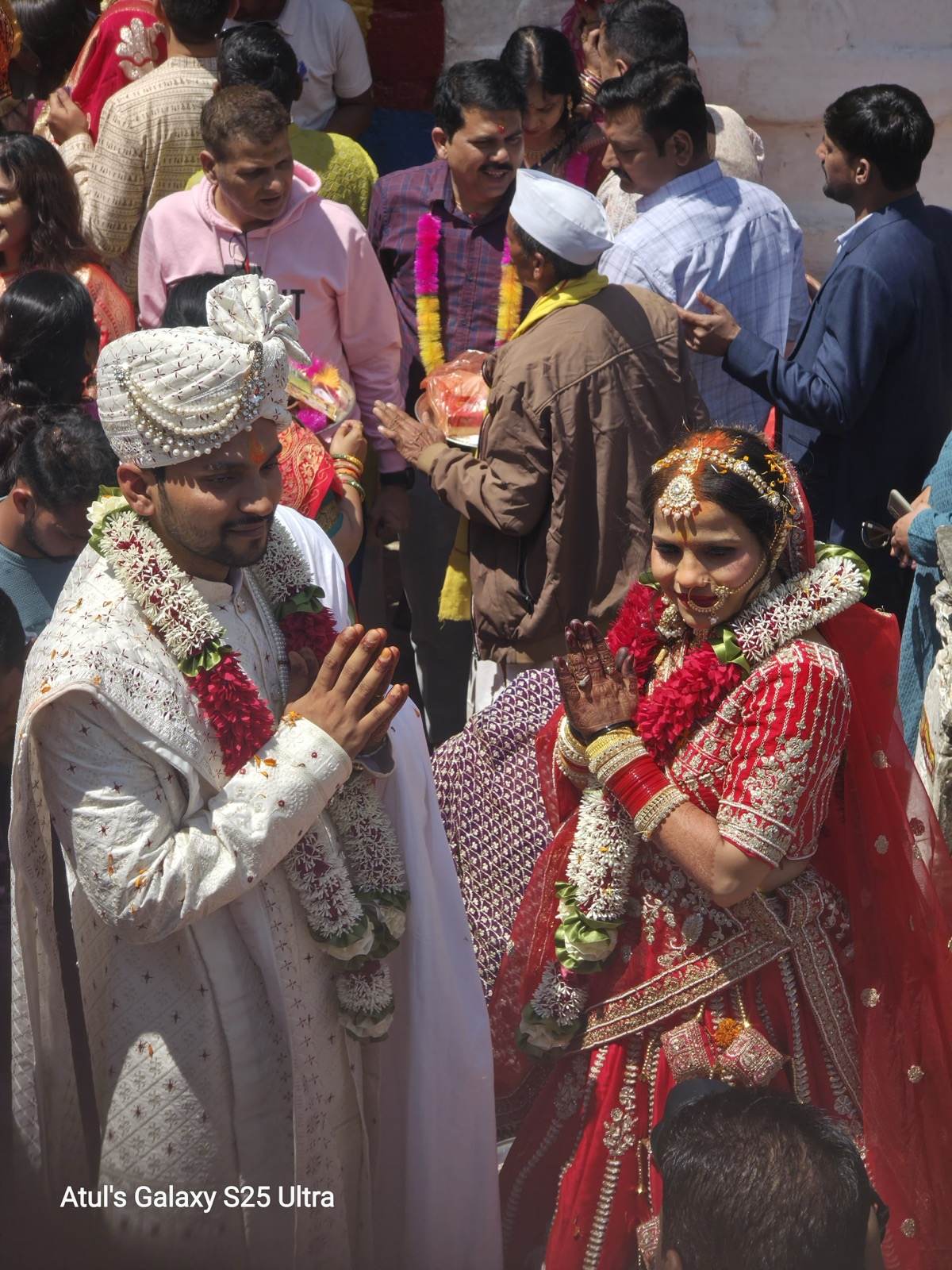 Garlanded bride and groom greeting guests after their wedding at Triyuginarayan Temple
