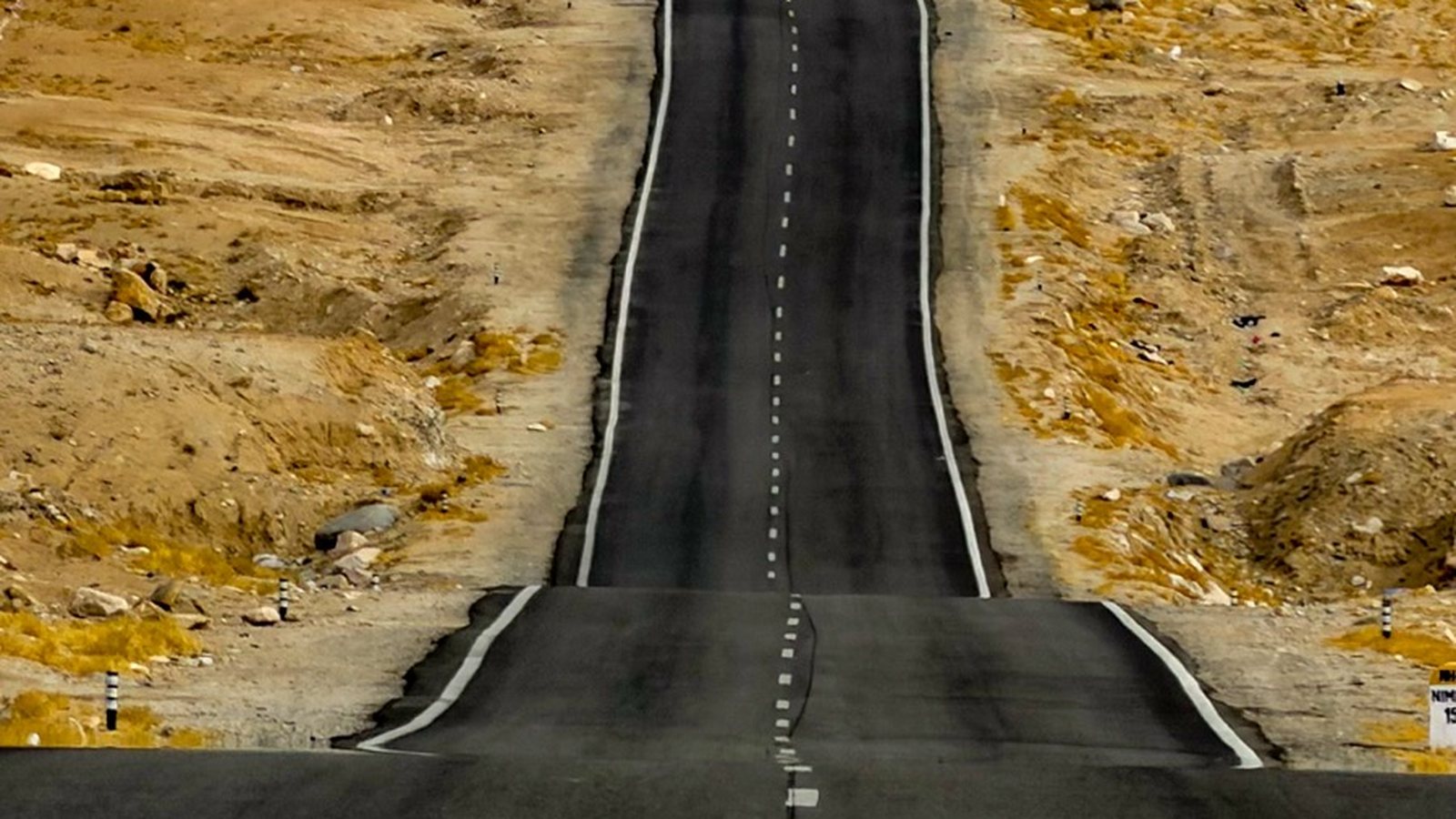 An empty highway running through the Ladakh plateau
