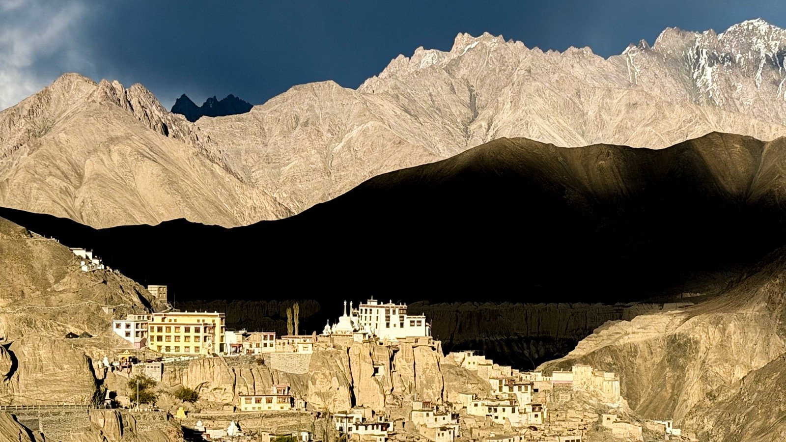 A hilltop palace below a dark mountain ridge, Ladakh
