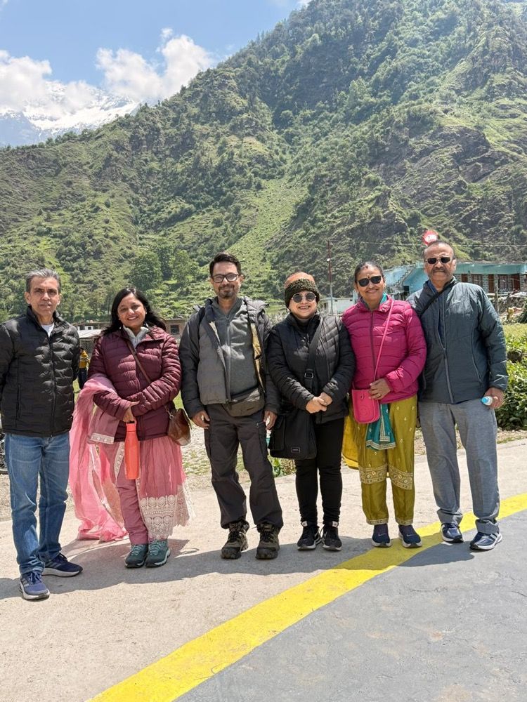 Saffron Chariot guests on a Himalayan road with snow peaks behind