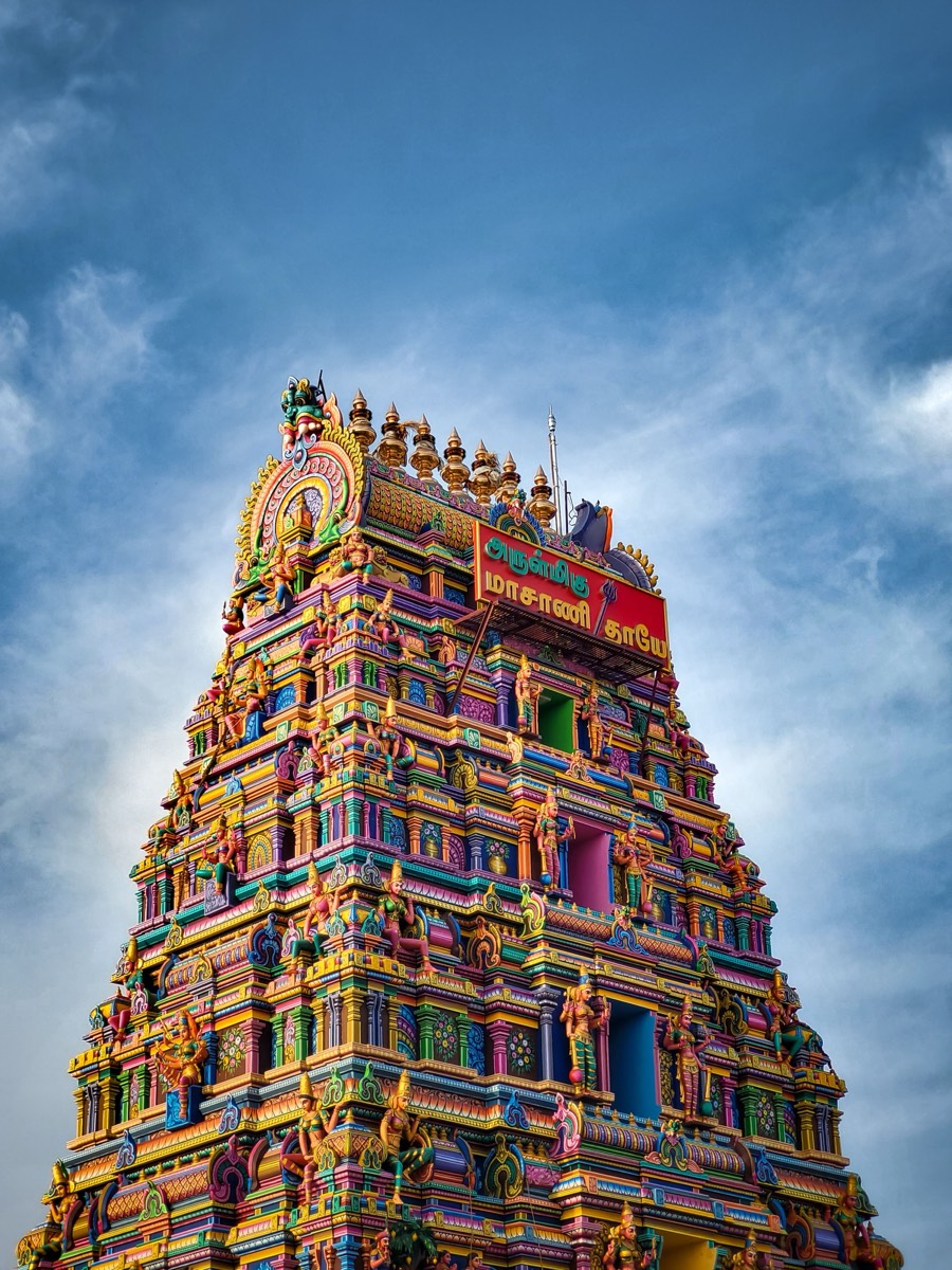 Close detail of painted stucco deities on a gopuram tier