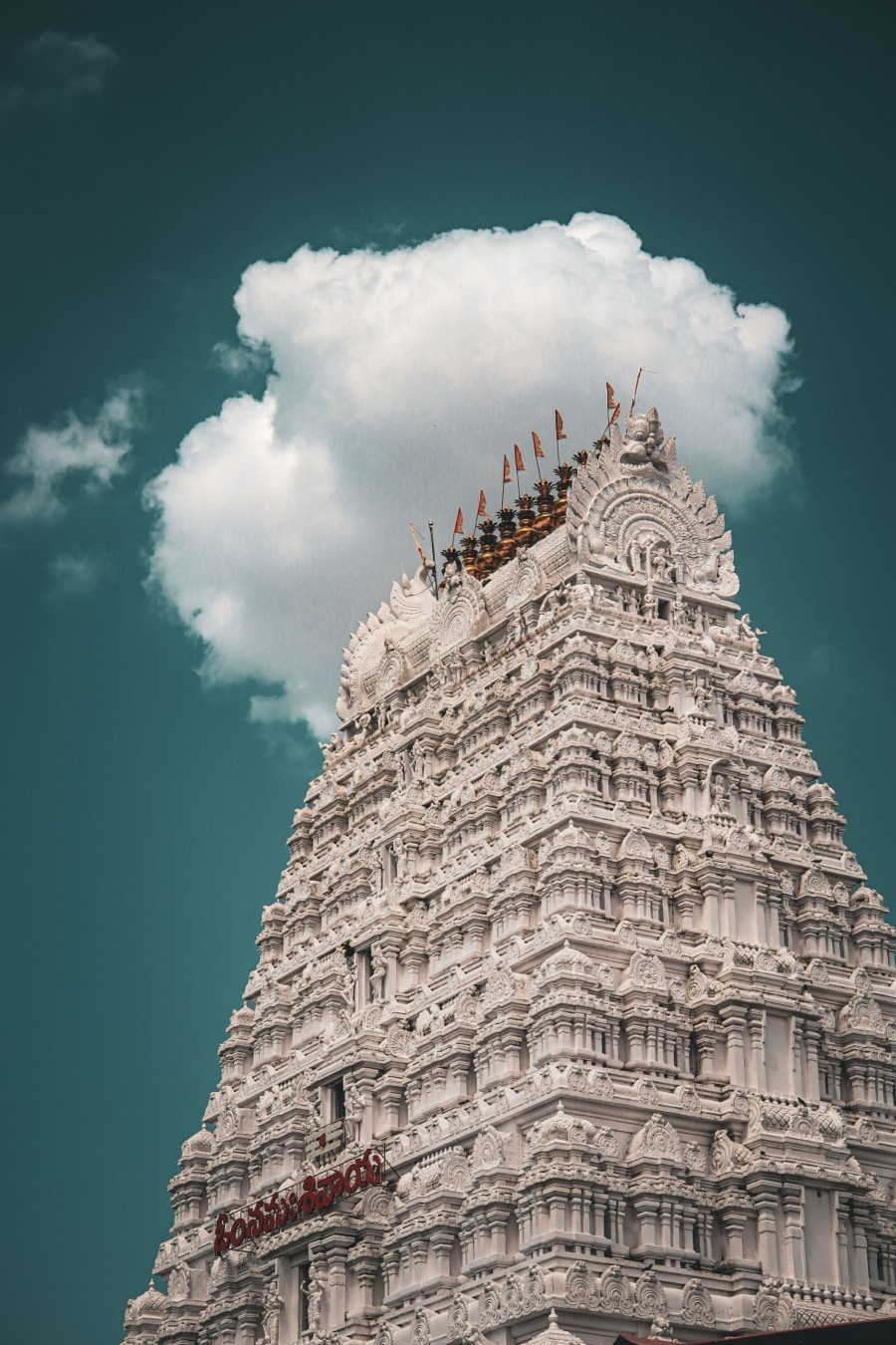 Whitewashed gopuram rising against a deep blue sky